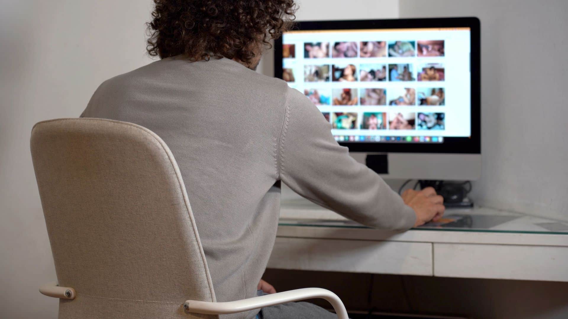 Mann am Computer vor verschwommener Bildergalerie, Escort Stuttgart